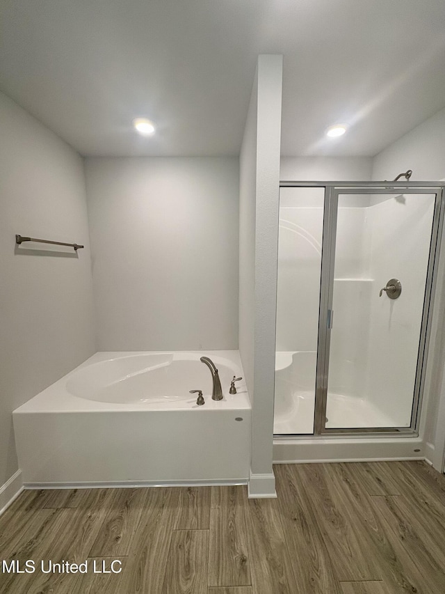 18059 Tiffany Renee Dr, Gulfport, MS 39503 - bathroom featuring wood finished floors, a bath, a stall shower, recessed lighting, and baseboards