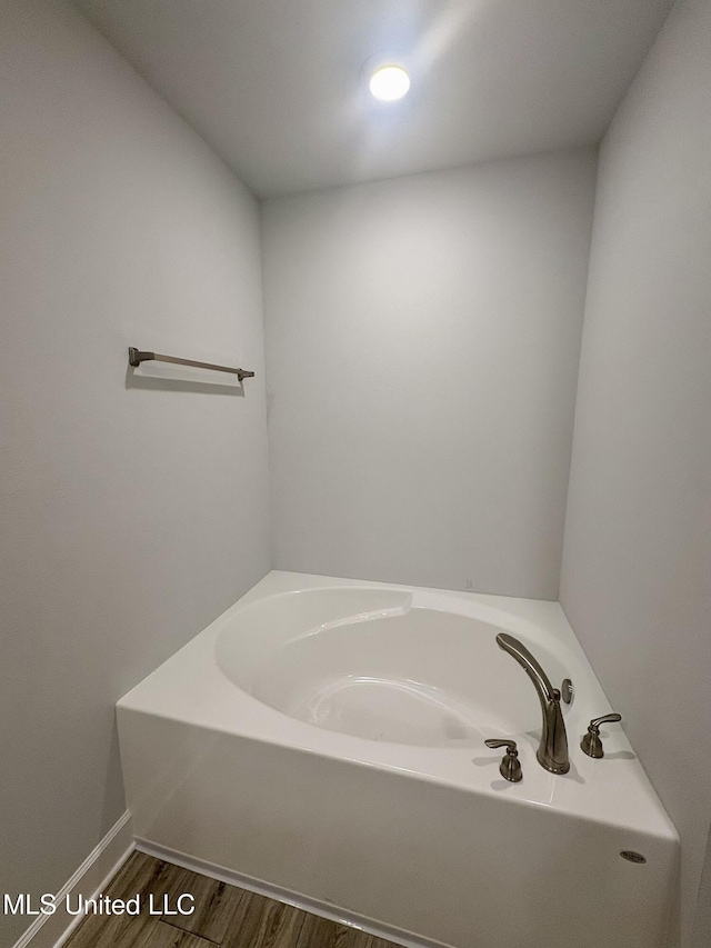 18059 Tiffany Renee Dr, Gulfport, MS 39503 - bathroom with a bath, wood finished floors, and baseboards