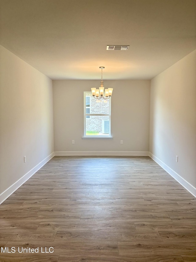 18059 Tiffany Renee Dr, Gulfport, MS 39503 - spare room featuring a chandelier, wood finished floors, and baseboards