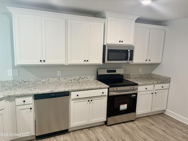 18059 Tiffany Renee Dr, Gulfport, MS 39503 - kitchen with stainless steel appliances, white cabinets, light wood finished floors, baseboards, and light stone counters