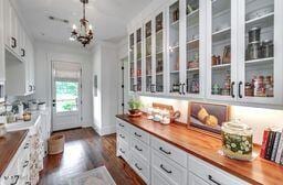 381 Parkinson Rd, Flora, MS 39071 - bar area featuring decorative light fixtures, dark wood-style floors, and a chandelier