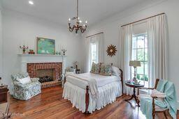 381 Parkinson Rd, Flora, MS 39071 - bedroom featuring multiple windows, a fireplace, wood finished floors, a chandelier, and recessed lighting