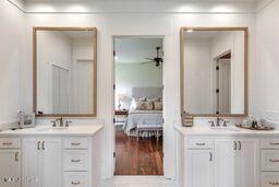 381 Parkinson Rd, Flora, MS 39071 - bathroom with two vanities, a ceiling fan, and wood finished floors