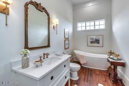 381 Parkinson Rd, Flora, MS 39071 - bathroom with a freestanding tub, vanity, toilet, and wood finished floors