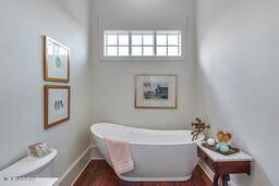 381 Parkinson Rd, Flora, MS 39071 - full bath with a soaking tub, wood finished floors, and baseboards
