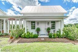 381 Parkinson Rd, Flora, MS 39071 - view of front of house featuring a porch, a front lawn, and metal roof
