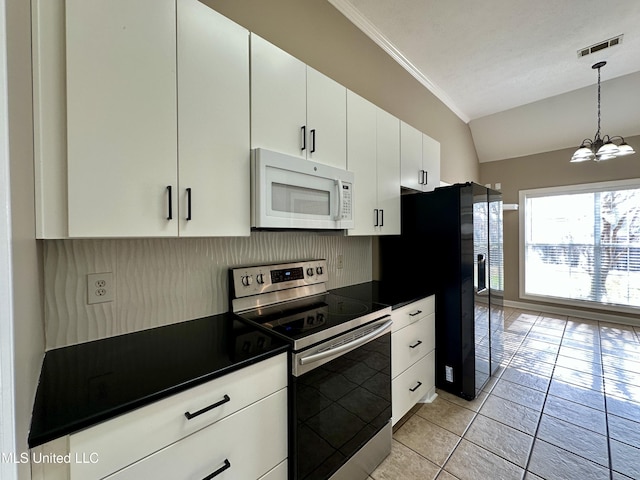 kitchen with stainless steel electric range, lofted ceiling, light tile patterned floors, a notable chandelier, and white cabinetry