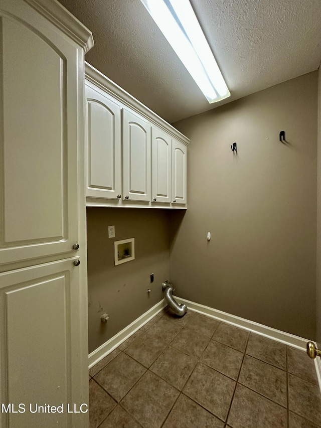 laundry room featuring electric dryer hookup, cabinets, hookup for a gas dryer, washer hookup, and dark tile patterned floors