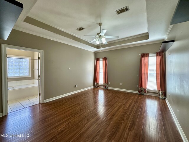 unfurnished room featuring hardwood / wood-style floors, ceiling fan, a raised ceiling, and crown molding