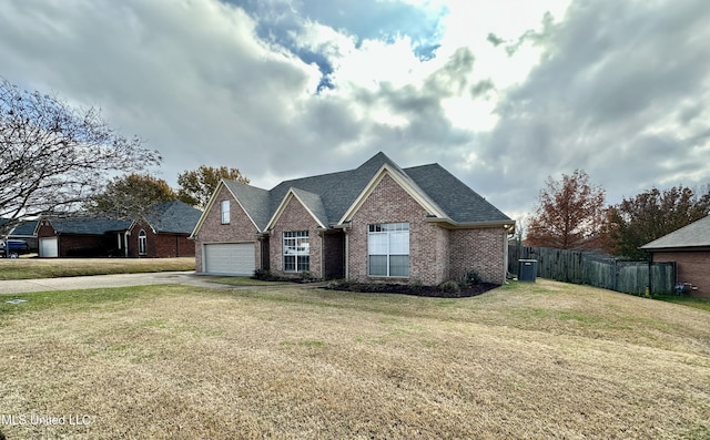 view of front of home featuring cooling unit, a front yard, and a garage