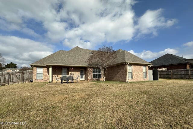 rear view of property with a lawn