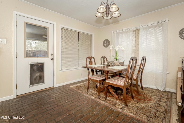 dining area with crown molding and a chandelier