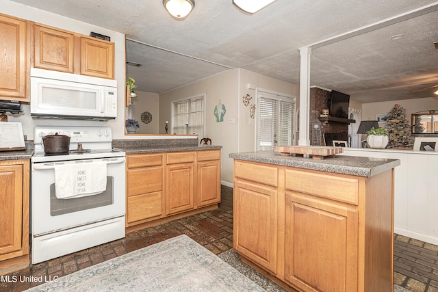 kitchen featuring a brick fireplace, a textured ceiling, white appliances, and kitchen peninsula