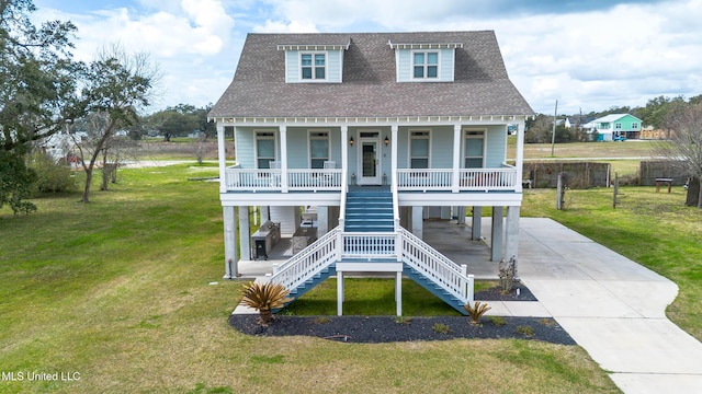 raised beach house with driveway, a porch, roof with shingles, a front lawn, and a carport