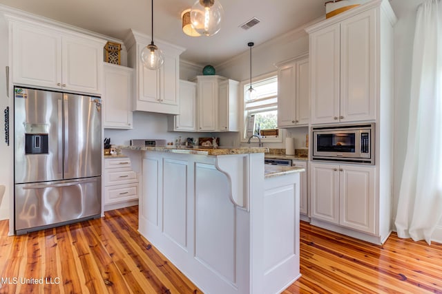 kitchen with light wood-style flooring, stainless steel appliances, visible vents, white cabinets, and crown molding