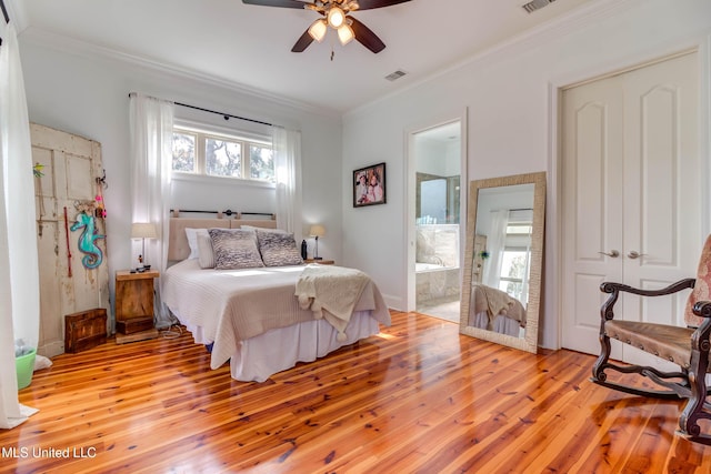 bedroom with ensuite bathroom, ornamental molding, visible vents, and light wood-style flooring