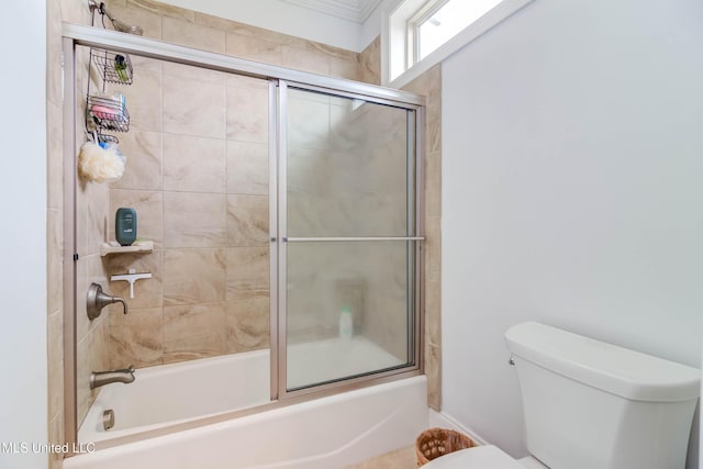 bathroom featuring enclosed tub / shower combo and toilet