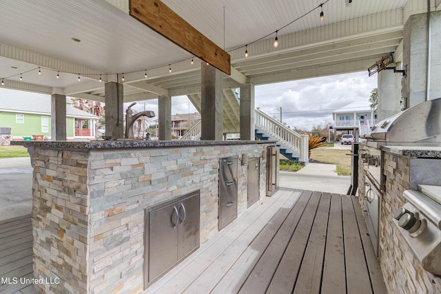 wooden deck with exterior kitchen and stairway