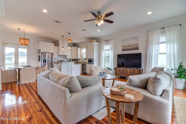 living area with a ceiling fan, recessed lighting, visible vents, and light wood-style flooring