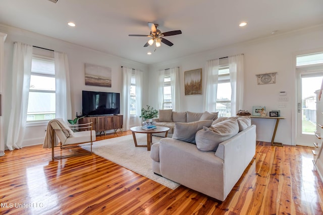 living room with light wood-style flooring, recessed lighting, a ceiling fan, baseboards, and crown molding