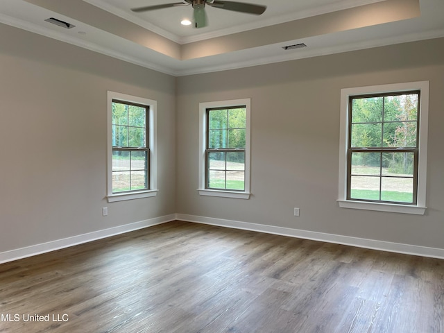 9092 Bennett Trl, Hernando, MS 38632 - unfurnished room with crown molding, a tray ceiling, healthy amount of natural light, ceiling fan, and dark wood-type flooring