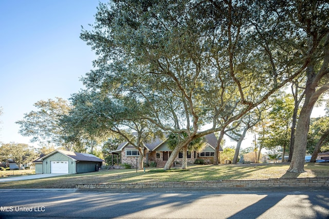 ranch-style home with a front lawn, an outdoor structure, and a garage