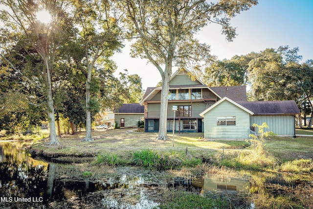 back of property featuring a balcony and a lawn