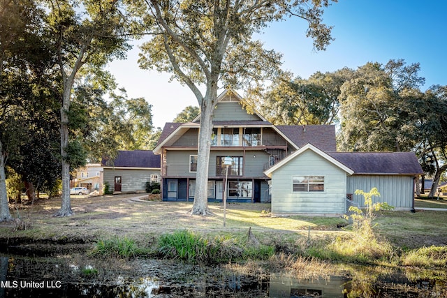 rear view of property featuring a yard and a balcony