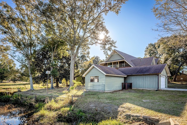 view of side of property featuring a lawn and a garage