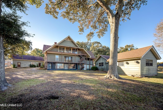 view of front of house featuring a balcony and a front lawn