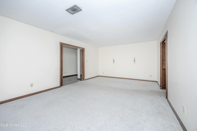 carpeted empty room featuring a textured ceiling