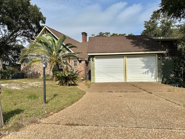 view of front of property featuring a front yard and a garage