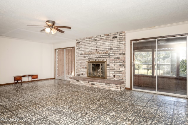 unfurnished living room featuring ceiling fan, a fireplace, a textured ceiling, and ornamental molding