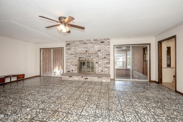 unfurnished living room featuring ceiling fan, a fireplace, crown molding, and a textured ceiling