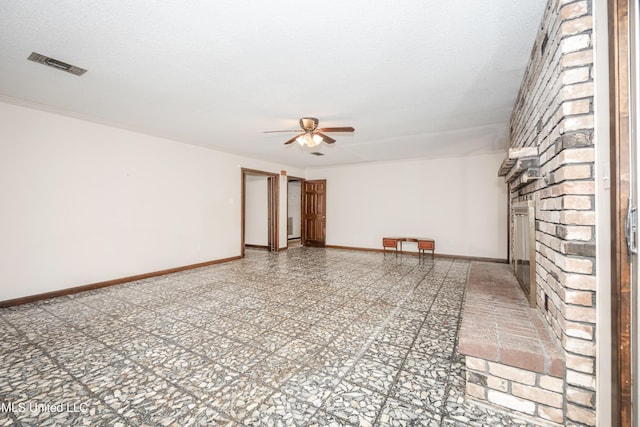 spare room featuring ceiling fan, a textured ceiling, and a brick fireplace