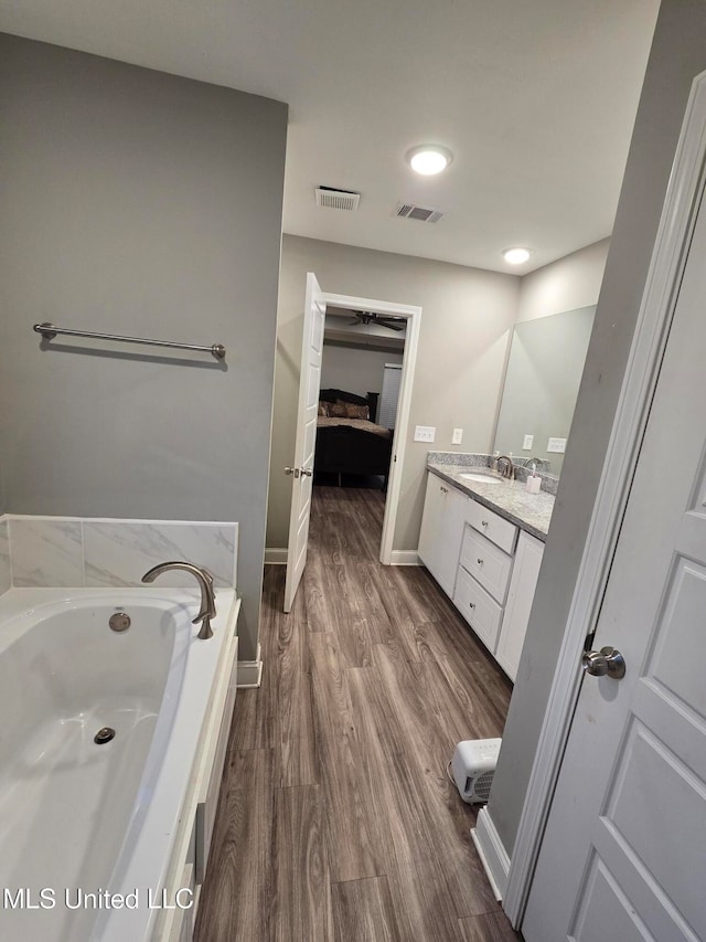 bathroom featuring vanity, hardwood / wood-style flooring, and a bathing tub