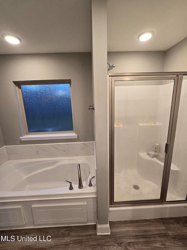 bathroom featuring hardwood / wood-style floors and separate shower and tub