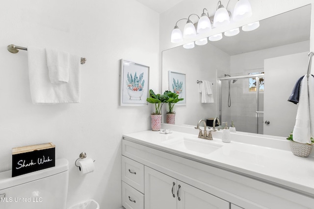 bathroom featuring toilet, vanity, and a shower with shower door