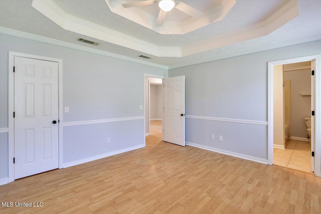 143 Glenwood Dr, Madison, MS 39110 - unfurnished bedroom featuring a raised ceiling, ornamental molding, light wood finished floors, ensuite bathroom, and a ceiling fan