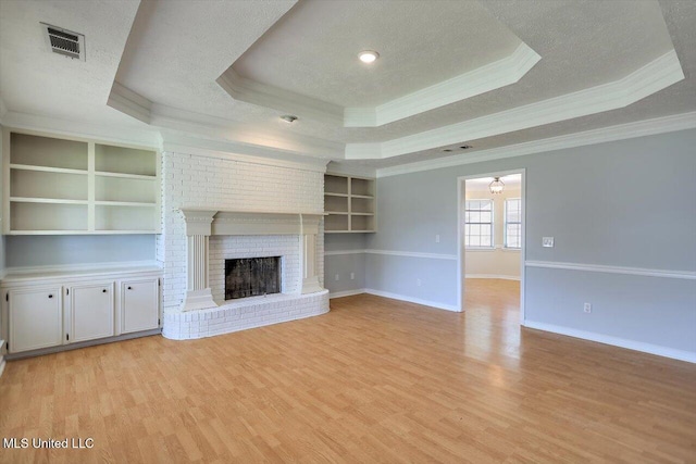 143 Glenwood Dr, Madison, MS 39110 - unfurnished living room with a raised ceiling, ornamental molding, light wood-type flooring, a textured ceiling, and a fireplace