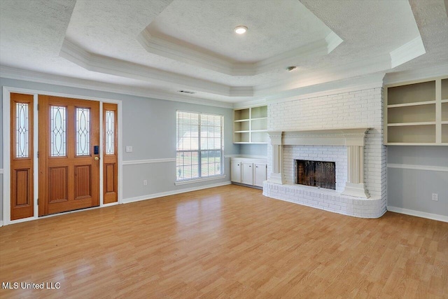 143 Glenwood Dr, Madison, MS 39110 - unfurnished living room with ornamental molding, a tray ceiling, a textured ceiling, light wood-style floors, and built in features