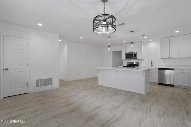 kitchen featuring appliances with stainless steel finishes, light countertops, visible vents, and white cabinetry