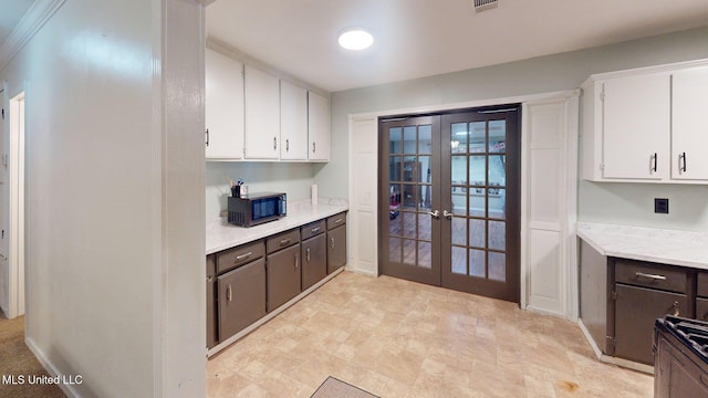 6400 Hans Rd, Moss Point, MS 39562 - kitchen featuring french doors, light countertops, white cabinetry, and dark brown cabinets