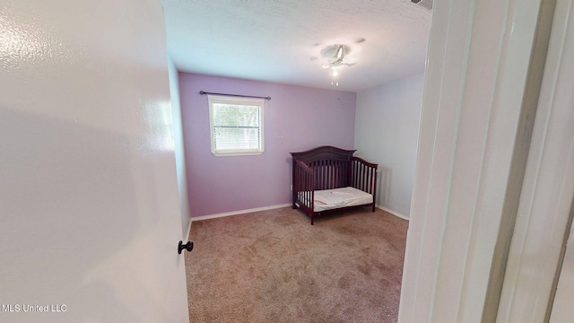 6400 Hans Rd, Moss Point, MS 39562 - unfurnished bedroom with carpet floors, baseboards, a crib, and a textured ceiling