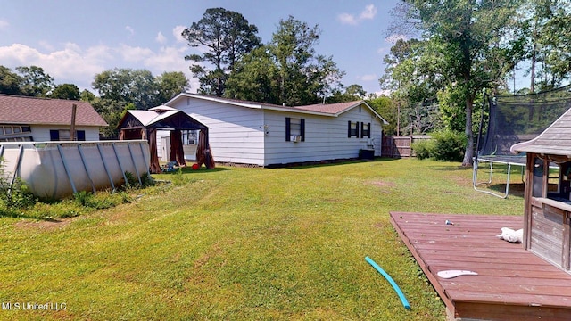6400 Hans Rd, Moss Point, MS 39562 - view of yard featuring a trampoline, a wooden deck, and an outdoor pool