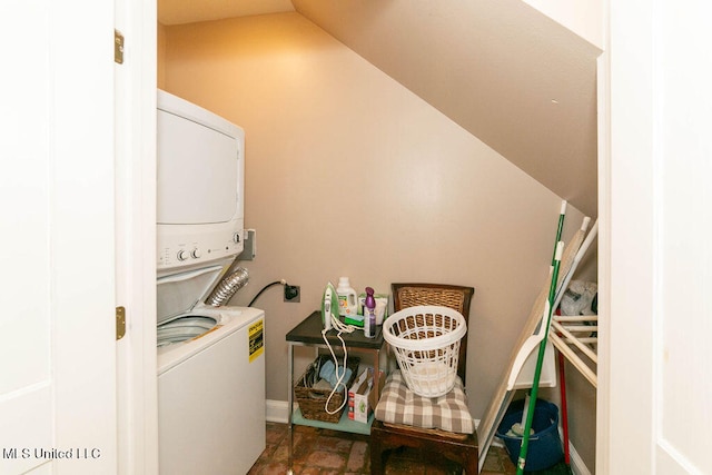 clothes washing area with stacked washer / dryer