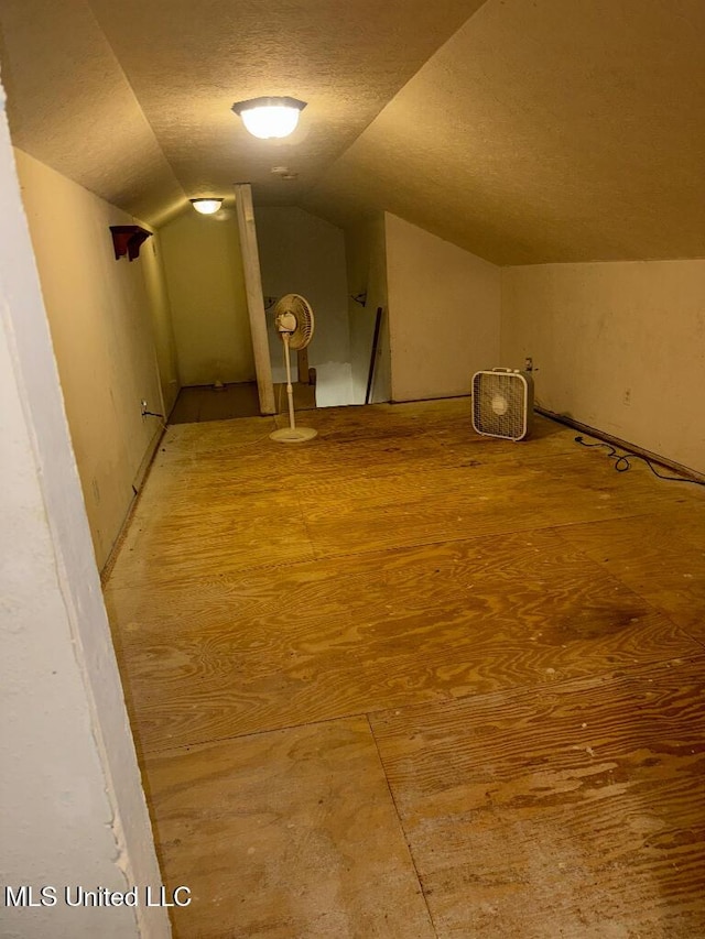 bonus room with vaulted ceiling and a textured ceiling