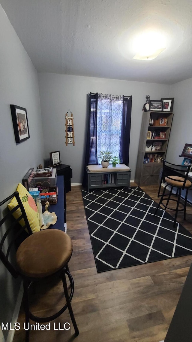 sitting room with dark wood finished floors and baseboards