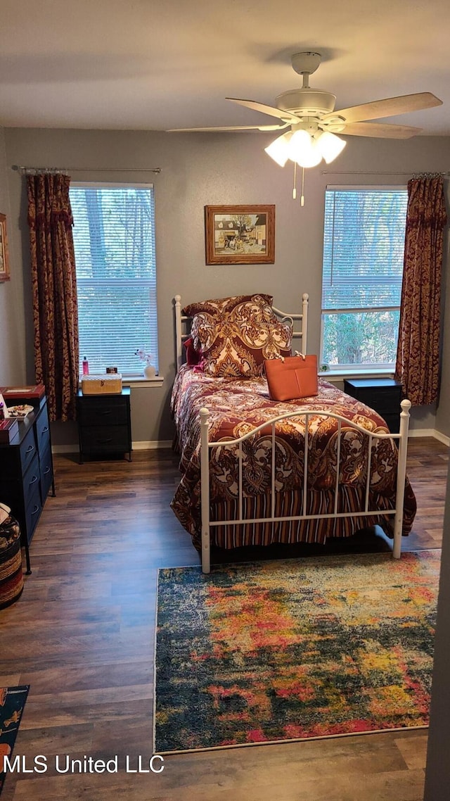 bedroom with ceiling fan, baseboards, and wood finished floors