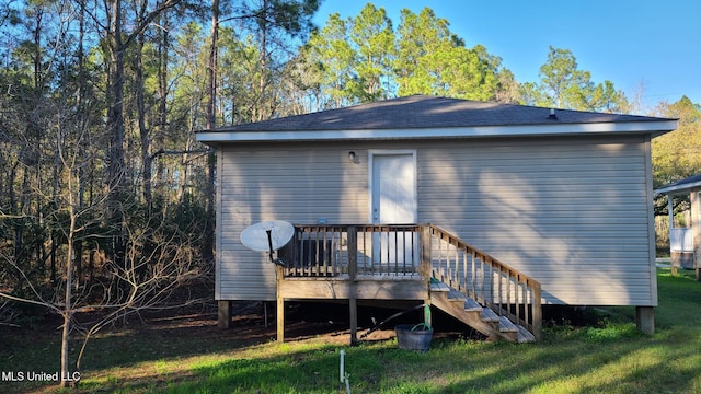 back of property with stairs, a deck, and a lawn